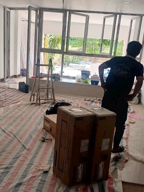 Kỹ thuật viên chuẩn bị mặt bằng, trải bạt bảo vệ sàn trước khi lắp đặt máy lạnh