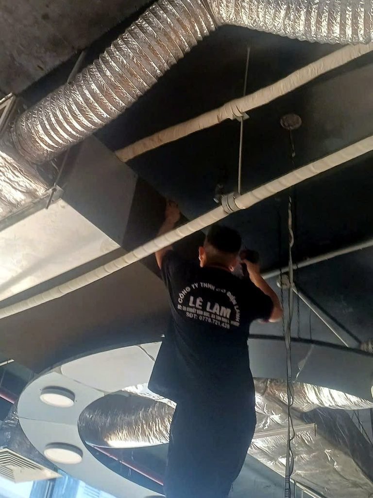 Kỹ thuật viên Điện Lạnh Lê Lâm kiểm tra máy lạnh nối ống gió trên trần nhà hàng